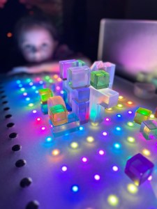 A castle of translucent acrylic blocks on a rainbow LED board at the Portland Children's Museum light exhibit.